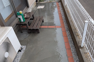 雑草の悩みを解消しレンガの縁取りで美しくデザインされた土間コンクリートのお庭